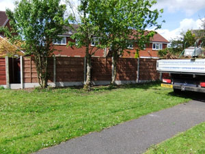 Waney lap fencing panel, with plain concrete bargeboards, finished installation.