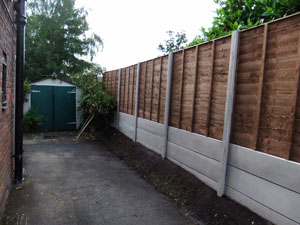 Waney lap fencing panel, with plain concrete bargeboards, finished installation.